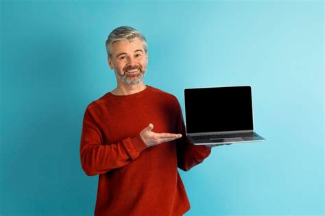 Premium Photo Cheerful Mature European Man Showing Laptop With Blank Screen Mockup