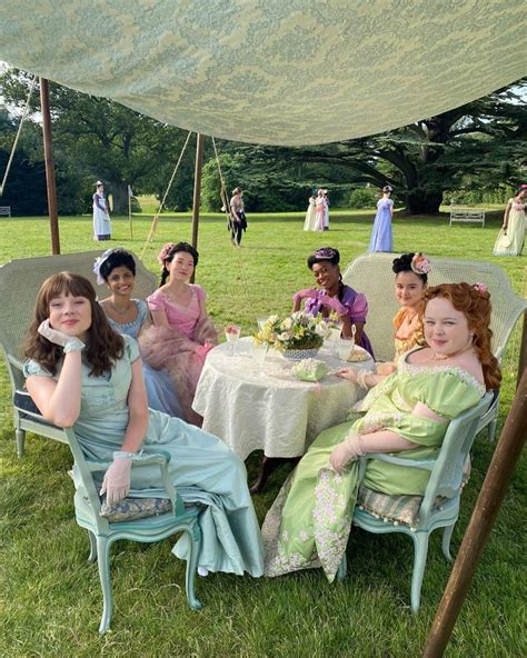 A Group Of Women Sitting Around A Table Under A Tent