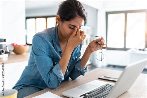 Stressed business woman working from home on laptop looking worried ...