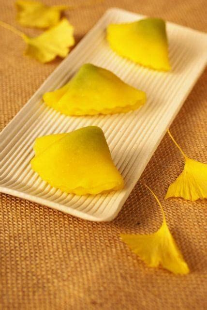 Some Yellow Leaves Are Laying On A White Plate