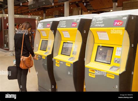 Una mujer compra un billete de tren en una máquina de billetes la Gare