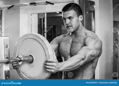 Hombre Muscular En El Gimnasio Que Realiza El Ejercicio Imagen De