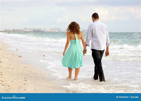 Young Couple Walking Hand In Hand On The Beach Thi Stock Image Image