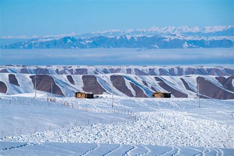 Small Wooden Hut At The Foot Of The Snow Covered Tianshan Mountains In