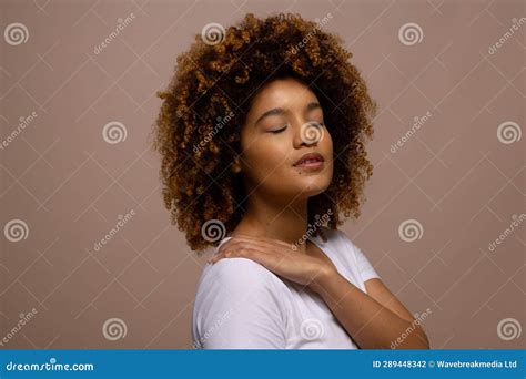 Biracial Woman With Dark Curly Hair With Hand On Shoulder And Closed