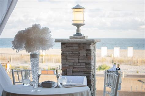 the table is set for an outdoor dinner overlooking the ocean and beach ...