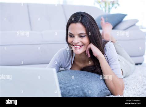 Smiling Beautiful Brunette Lying On The Floor And Using Her Laptop Stock Photo Alamy