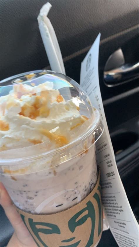 A Person Holding Up A Starbucks Drink With Whipped Cream And Toppings