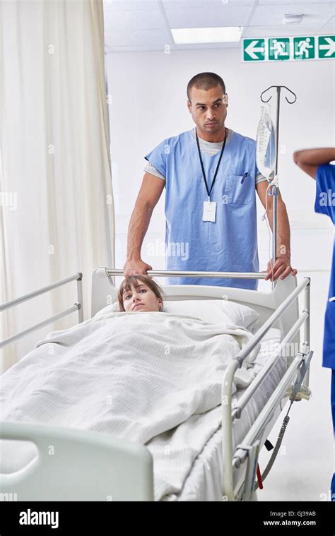 Nurse pushing patient in hospital bed Stock Photo - Alamy