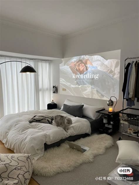 A Bed Room With A Neatly Made Bed And A Big Screen Tv On The Wall