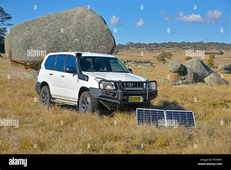 White Toyota Landcruiser Prado 120 Series With Portable Solar Panels Charging Second Battery At