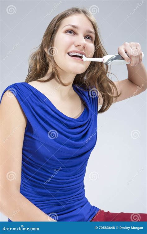 Portrait Of Caucasian Teenage Girl Brushing Her Teeth Braces With