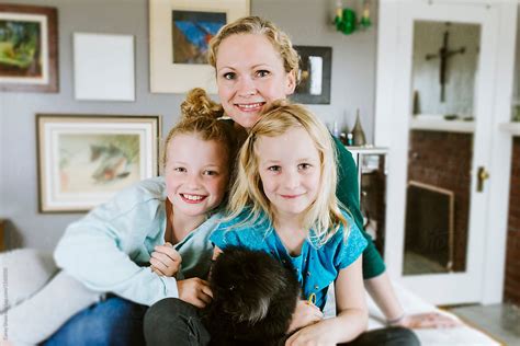 Mother And Daughters Cuddling Together At Home By Stocksy Contributor