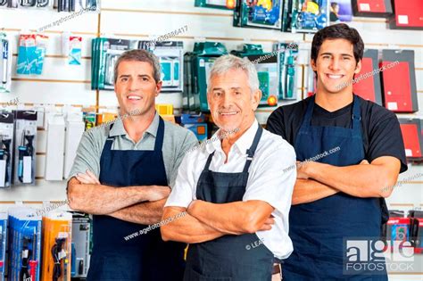 Portrait Of Happy Salesmen Standing Arms Crossed In Hardware Store