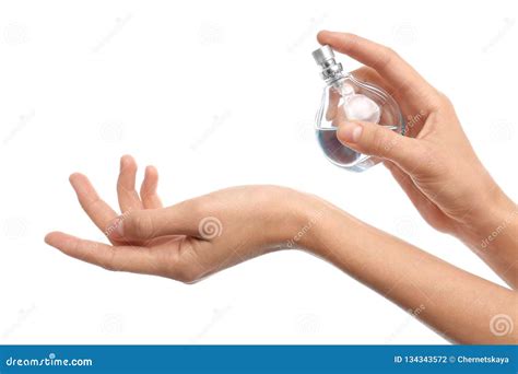 Young Woman Spraying Perfume Onto Skin Against White Background Stock