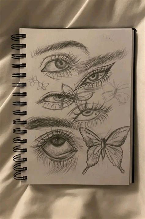 An Open Notebook With Drawings Of Eyes And Butterflies On The Pages