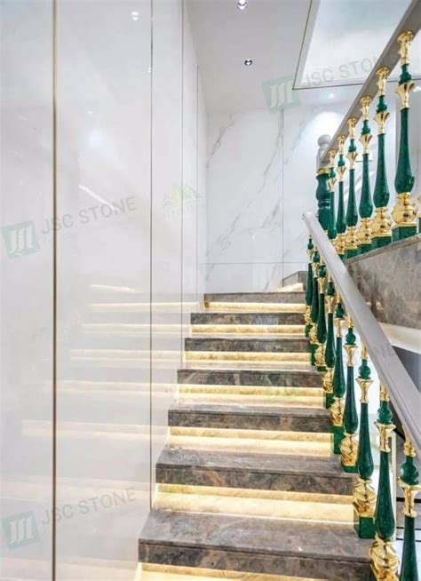 A Marble Staircase With Gold And Green Railings