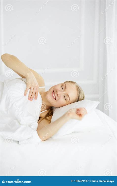 Smiling Woman Stretching Hands In Bed After Waking Up Entering A Day