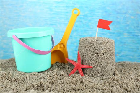 Premium Photo Sandcastle With Flag And Plastic Bucket Spade On Sandy