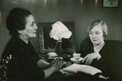 Two Women Sitting At A Table With An Open Book