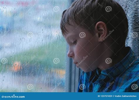 Boy Looks Out the Window in the Rain and is Sad. Stock Image - Image of ...