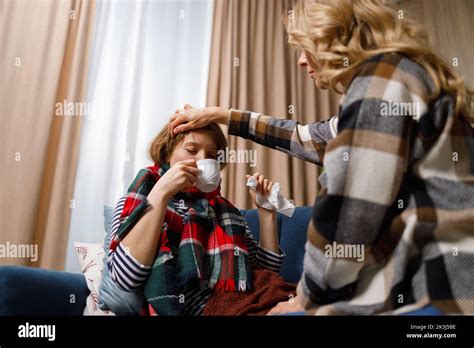 La mère mature prend soin de sa fille qui est malade de la grippe