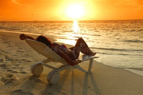 Mulher Na Chaise Sala De Estar Que Relaxa Na Praia Foto De Stock