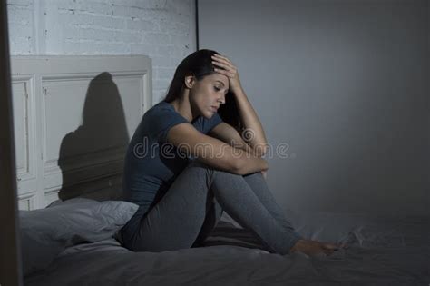 Mujer Latina Triste Y Deprimida Hermosa Que Se Sienta En La Cama En Casa F Imagen De Archivo