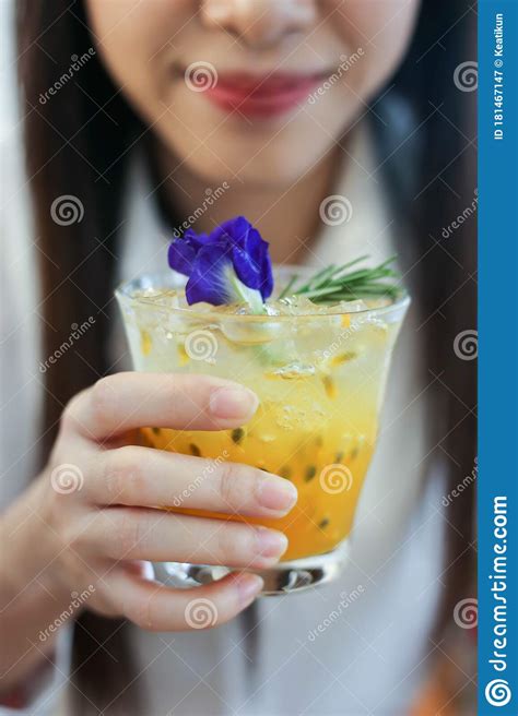 Close Up A Beautiful Woman With Passion Fruit Juice Iced In A Glass On Wooden Table In Cafe