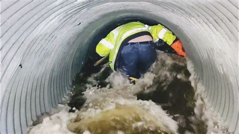 Unclogging Culvert To Drain Roadway - YouTube