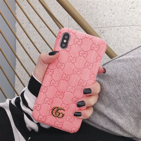 A Woman Holding Up Her Pink Gucci Phone Case