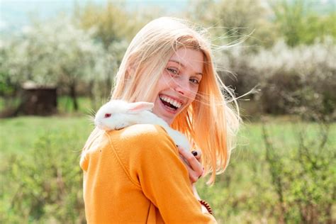 Premium Photo Funny Girl Hold Rabbit On Green Field Background