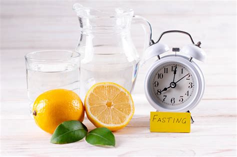 Intermittent Fasting Fasting Time Alarm Clock And Lemon Water On White