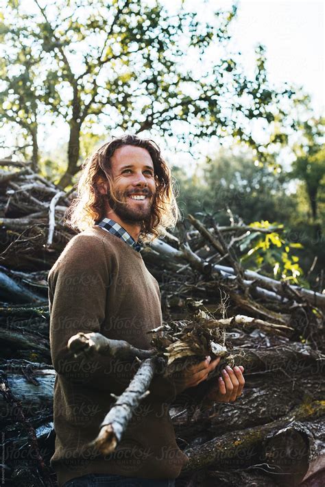 Man Holding A Stack Of Trunks In The Forest Del Colaborador De