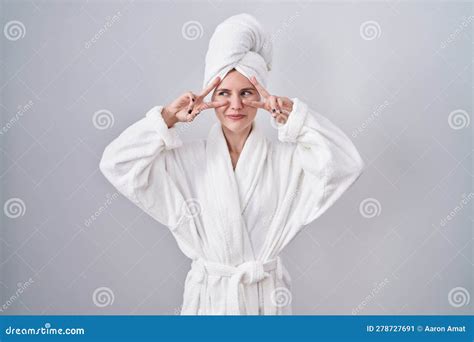 Blonde Caucasienne Femme En Peignoir Faisant Le Symbole De La Paix Avec Les Doigts Sur Le Visage