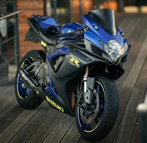 A Blue Motorcycle Parked On Top Of A Wooden Deck