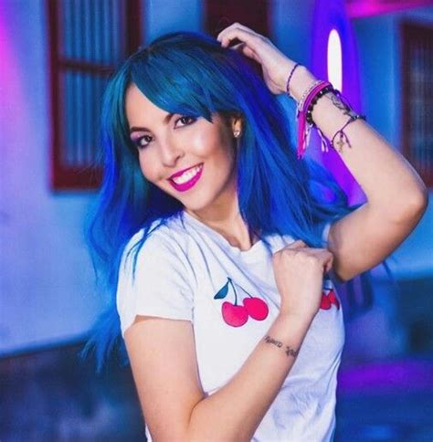 A Woman With Blue Hair Is Posing For The Camera