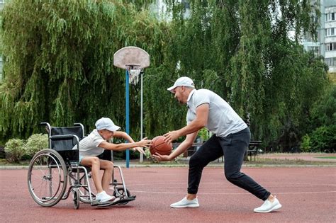 Premium Photo Dad Plays With His Disabled Son On The Sports Ground