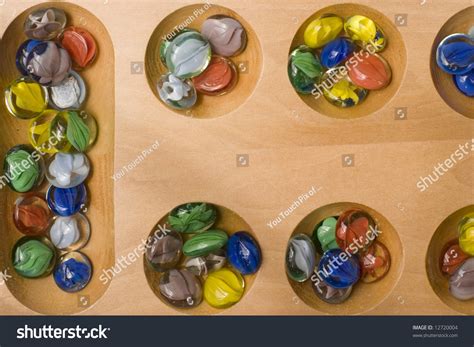 Colored Stones Of Mancala Game In Their Holes On Board Stock Photo