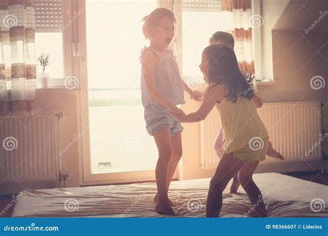 Petites Filles Ayant L Amusement Ensemble Dans Le Lit Image Stock