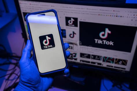 Hand Holding A Apple IPhone 14 Pro Max Smartphone With TIK TOK Logo It