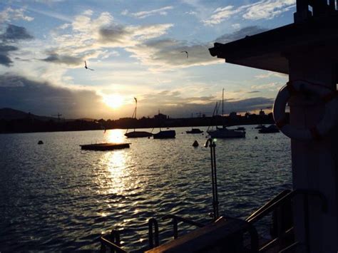 The Sun Is Setting Over Some Boats In The Water