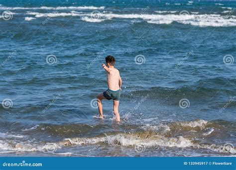 El Muchacho Que Salta En Ondas Del Mar Con Agua Salpica Concepto Imagen