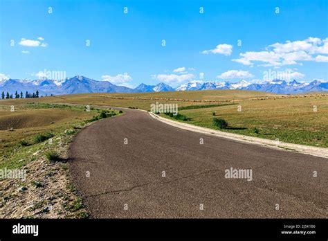 Asphalt Road And Mountain With Beautiful Sky Clouds Under Blue Sky