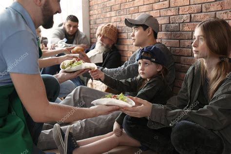 Volunteers giving food to poor people indoors - Stock Photo , # ...