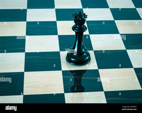 Black queen on a chess board. Chess piece Stock Photo - Alamy