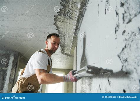 Plasterer Using Screeder Smoothing Putty Plaster Mortar On Wall Stock