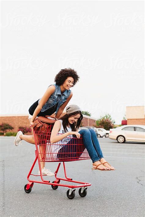 Two Young Women Sitting In A Shopping Cart