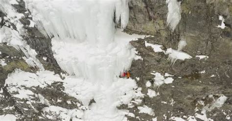 Extreme mountain climbers on frozen cascade ledge dynamic aerial, Stock ...