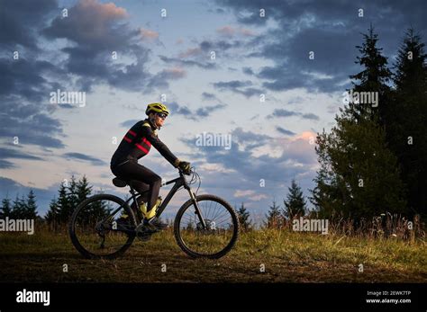 Horizontal Snapshot Of Man Cyclist Riding Bike On Sunset In The